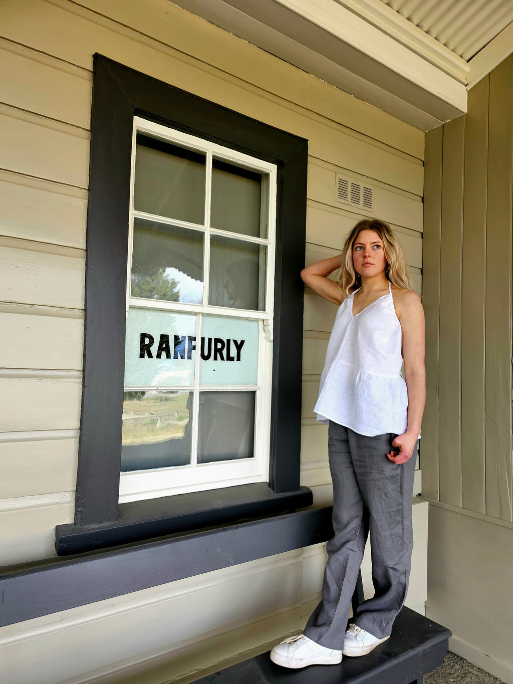 Outside Ranfurly store: "Mt Buster linen pants in natural white worn outside Ranfurly store, relaxed fit, handmade by Lohi Linen Central Otago"