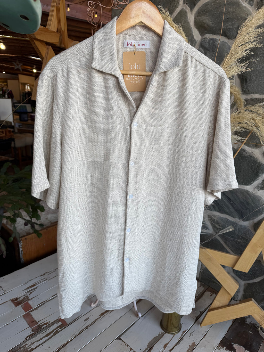 Shirt on hanger: "Patearoa men's linen shirt in natural oat on hanger showing camp collar detail, handmade by Lohi Linen, Central Otago"
