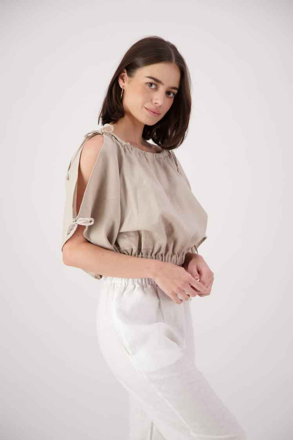 Front close up: "Naseby linen top in tan front view showing puff sleeve detail and gathered neckline, handmade by Lohi Linen in Ranfurly, New Zealand"