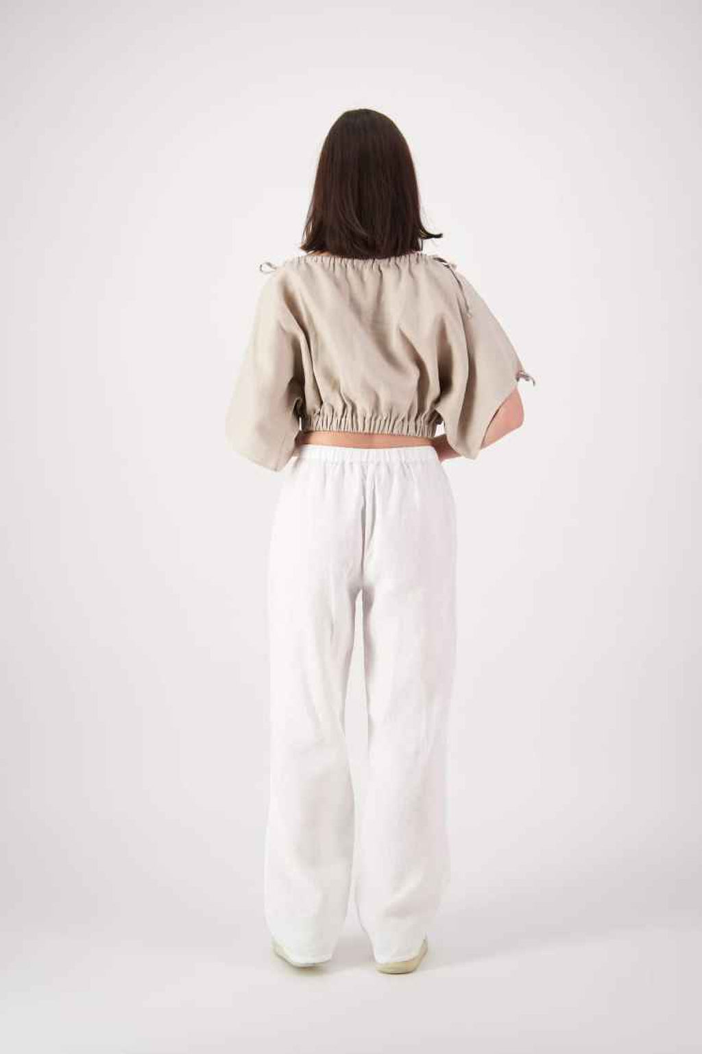 Full length back: "Naseby linen top in tan back view with white linen pants, relaxed cropped fit, handmade by Lohi Linen in Central Otago"