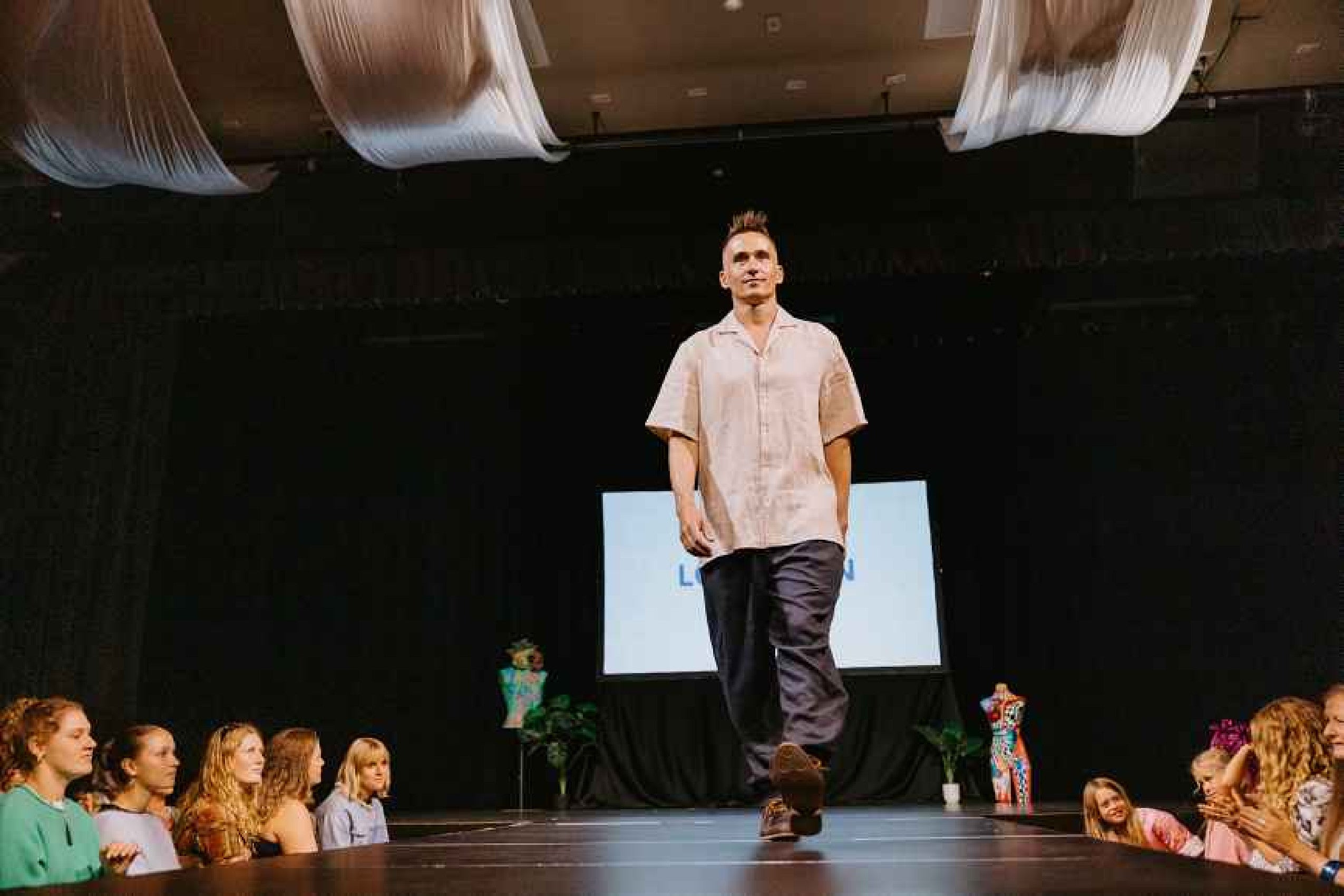 Runway shot: "Patearoa men's linen shirt in natural oat, relaxed short sleeve camp collar, worn on runway, handmade by Lohi Linen in Central Otago, New Zealand"