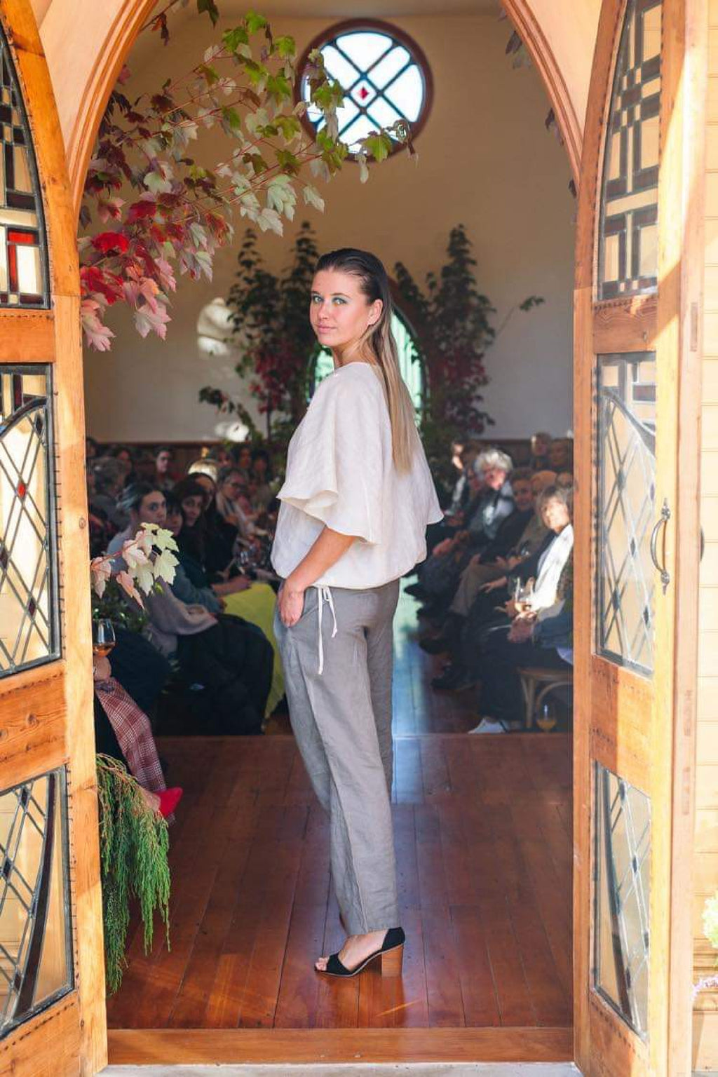 1. Main shot: "Paerau linen top in natural oat, relaxed wide flutter sleeve with pintuck front and drawstring hem, worn at fashion show, handmade by Lohi Linen in Central Otago"